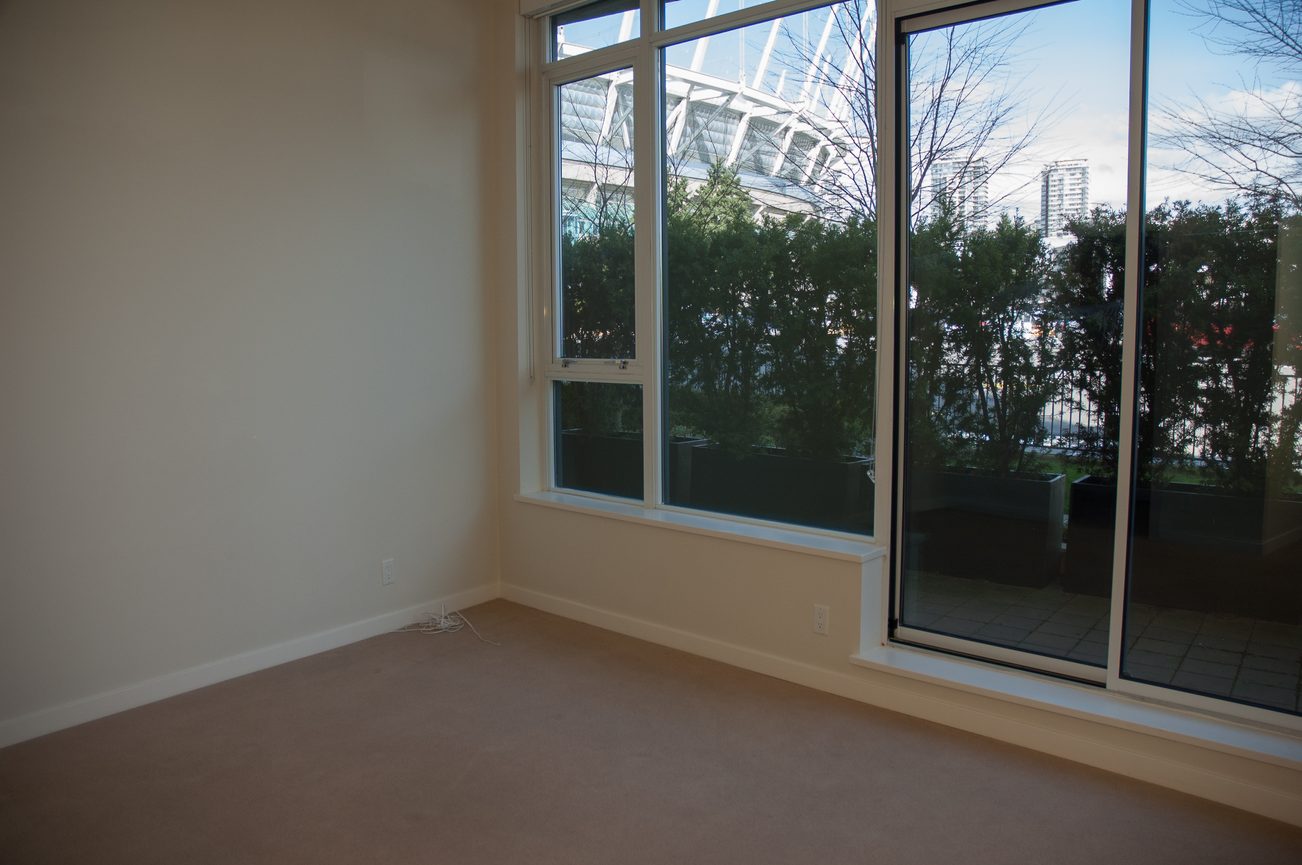 Bright living room with large windows and city view. - 100-9 Smithe Mews, Vancouver Downtown