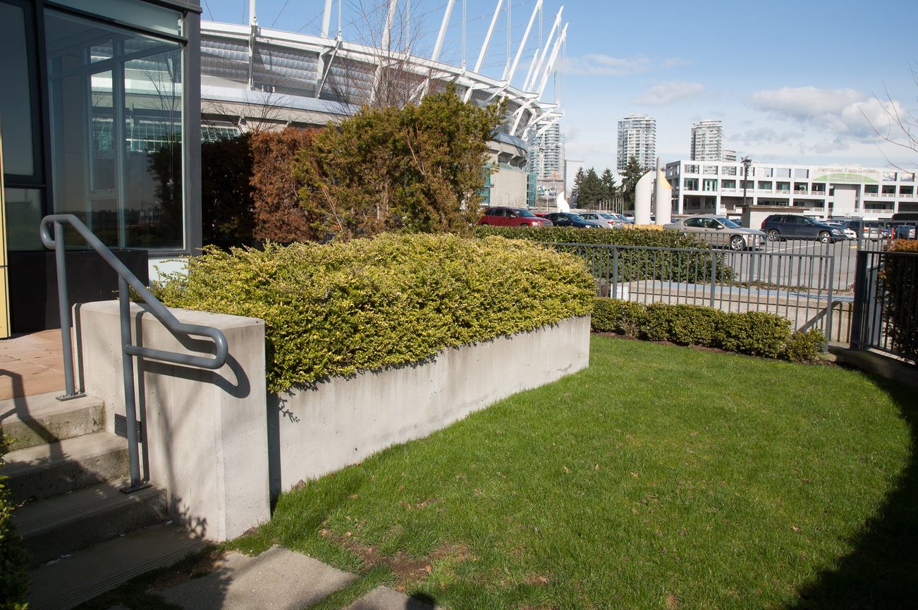 Lush green lawn and modern balcony with city view. - 100-9 Smithe Mews, Vancouver Downtown