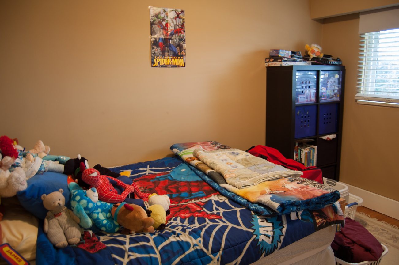 Bright bedroom with Spider-Man theme, stuffed toys, and a Spider-Man poster. - MAIN - 451 East Keith Road, North Vancouver