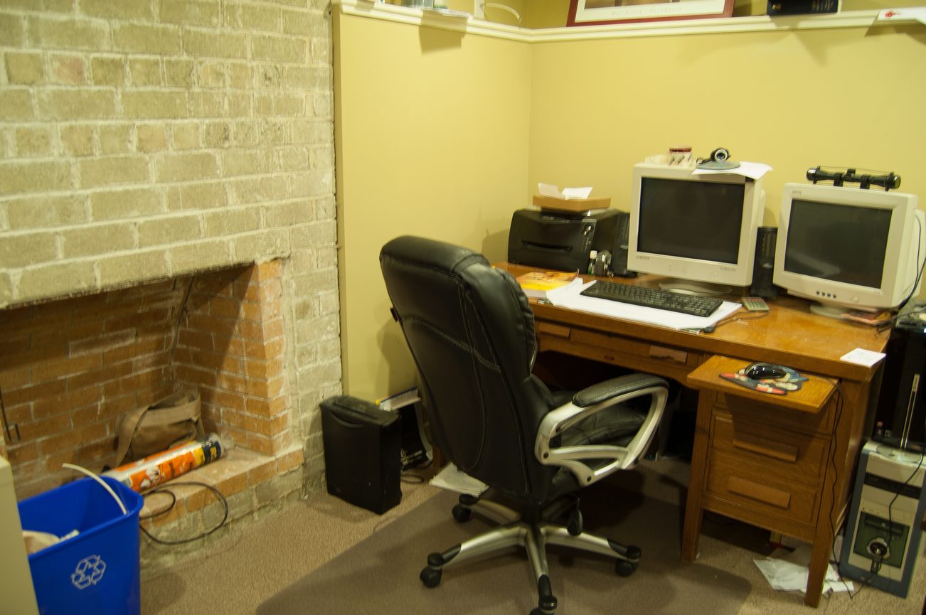 Small office with wooden desk, two monitors, and a black office chair. - MAIN - 451 East Keith Road, North Vancouver