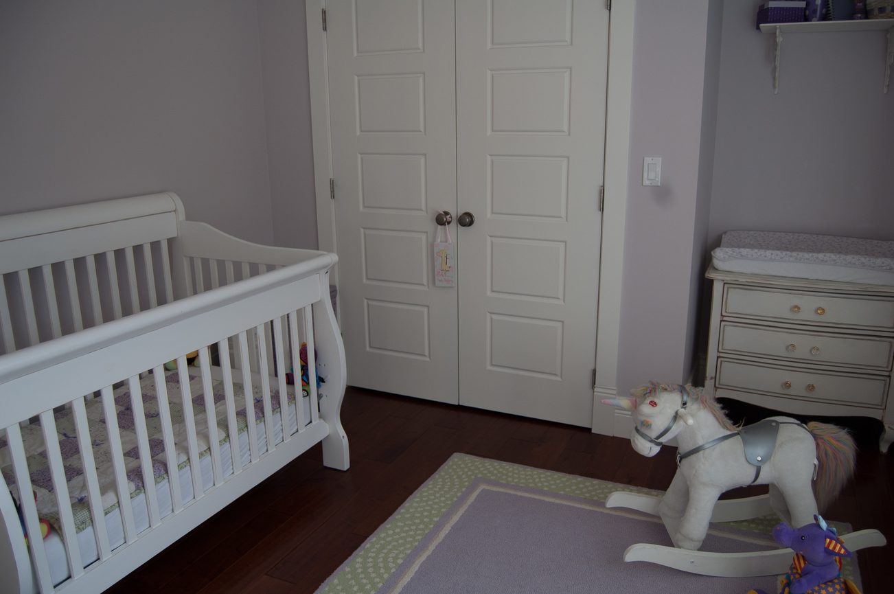 Bright nursery with white crib, changing table, and rocking horse; hardwood floors. - 186 West 23rd Ave, Vancouver West Side