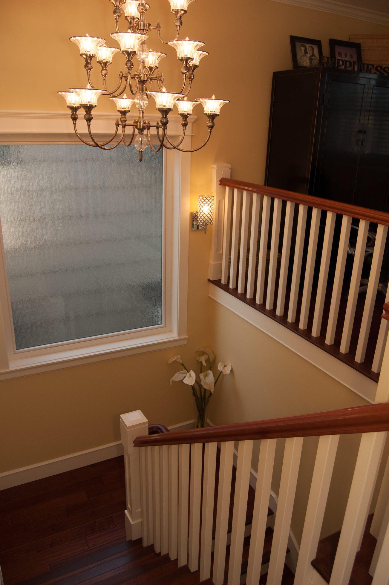 Staircase with chandelier, hardwood floors, and frosted window. - 186 West 23rd Ave, Vancouver West Side