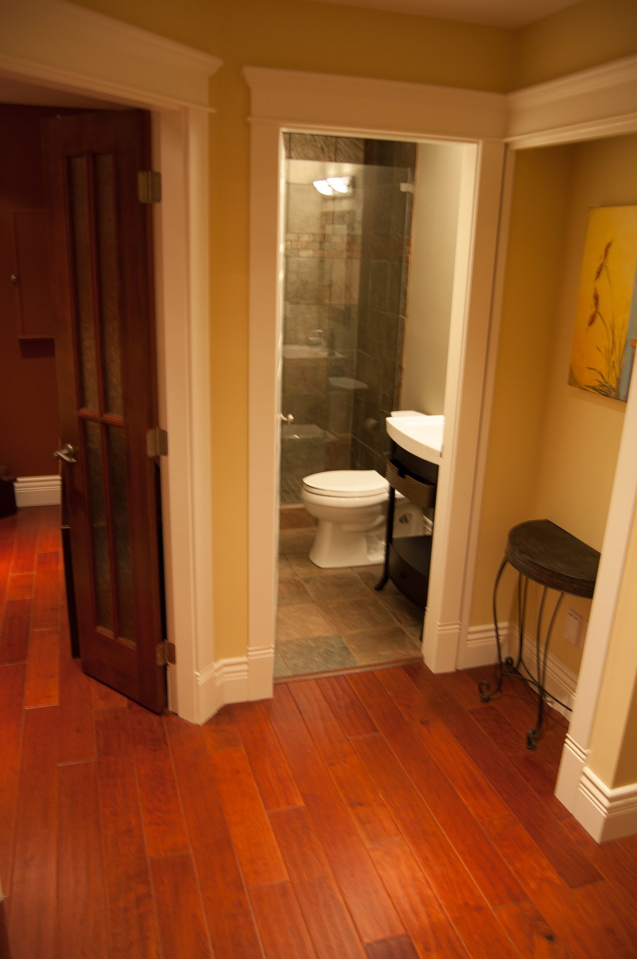 Bathroom with hardwood floors, glass shower, and wooden door. - 186 West 23rd Ave, Vancouver West Side