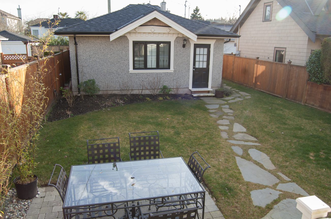 Furnished patio with outdoor furniture and stone path leading to a cozy house. - 186 West 23rd Ave, Vancouver West Side