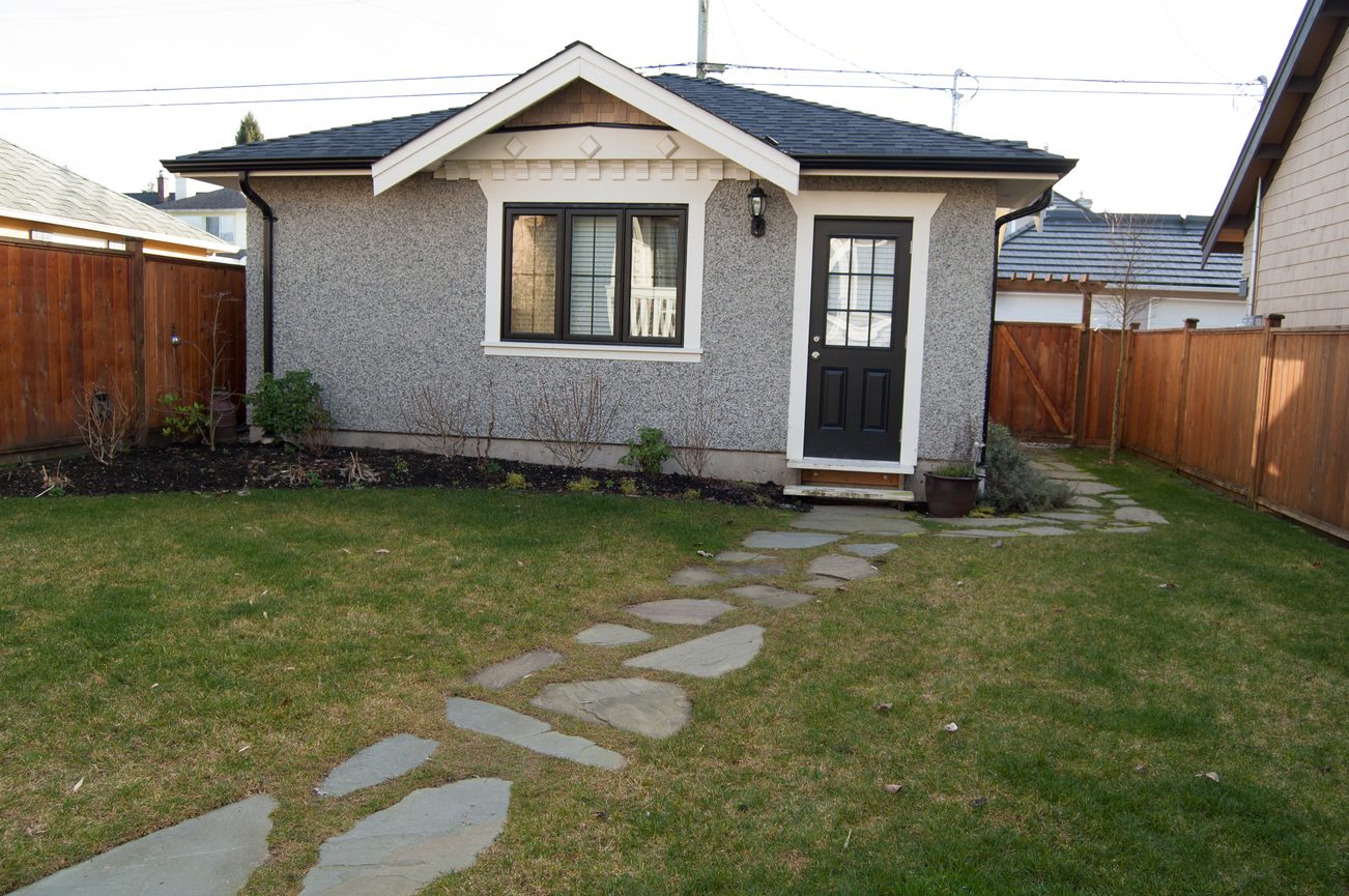 Bright front yard with stone pathway leading to a black door and windows. - 186 West 23rd Ave, Vancouver West Side