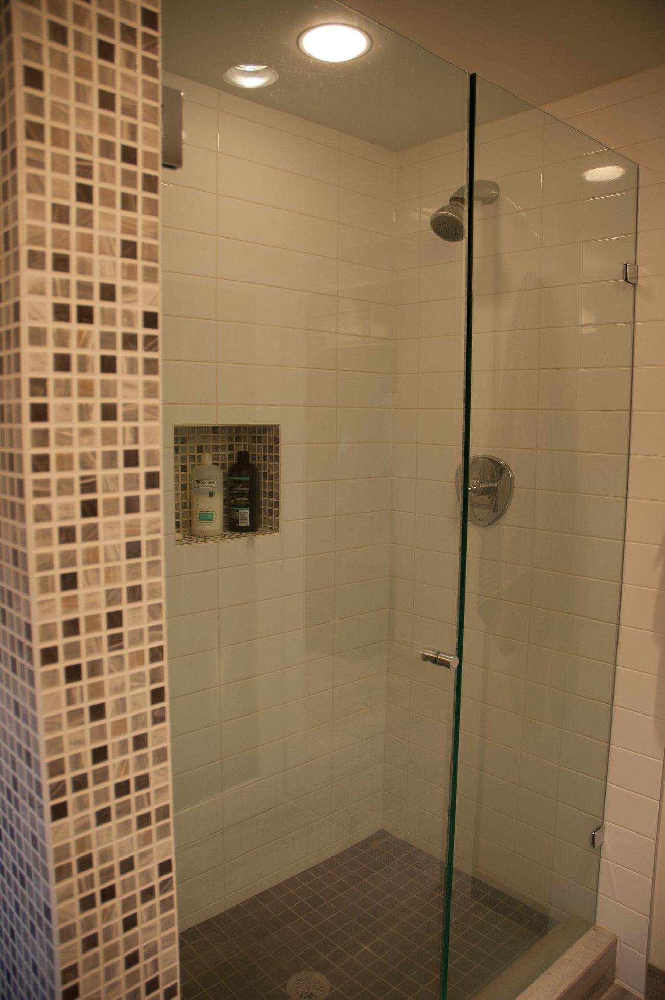 Shower with glass door, mosaic tile accent, and built-in shelf. - 3925 Viewridge Place, West Vancouver