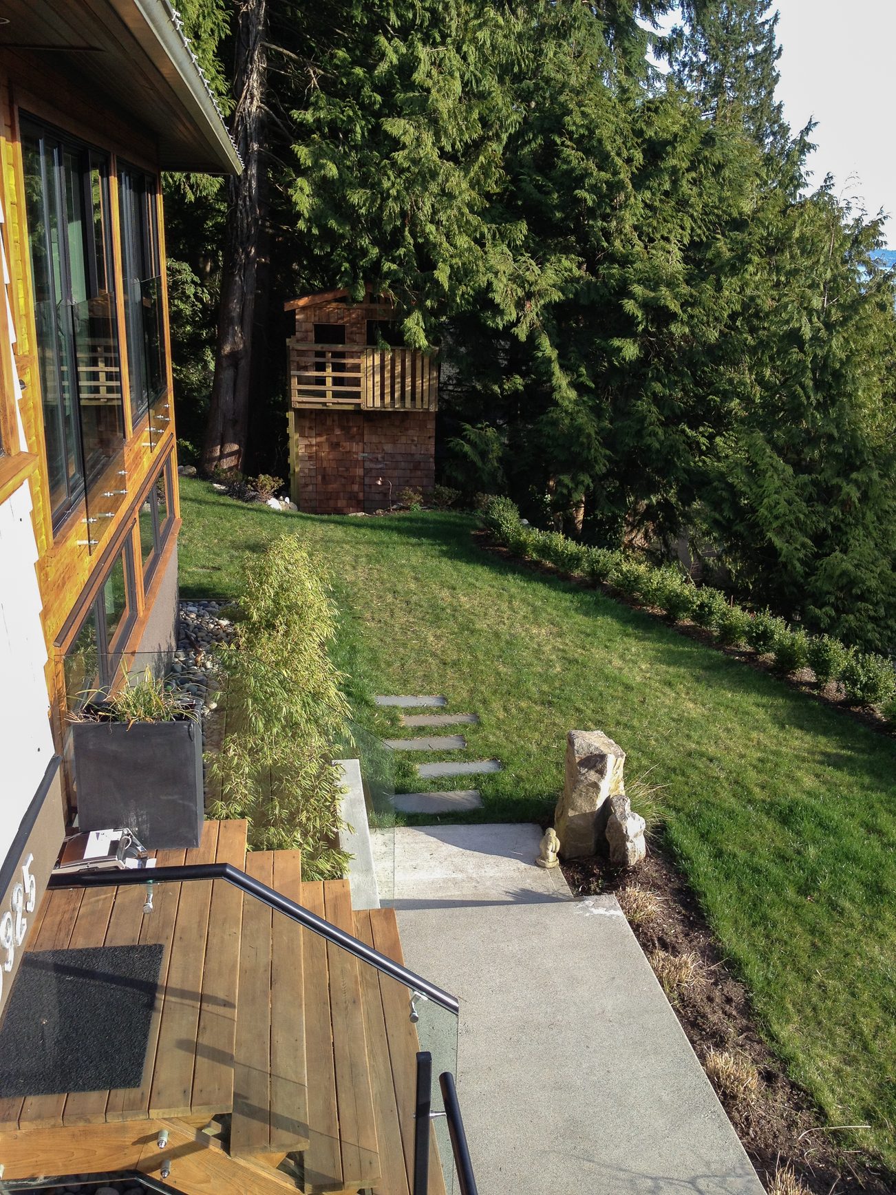 Furnished living room with wooden deck and lush greenery. - 3925 Viewridge Place, West Vancouver