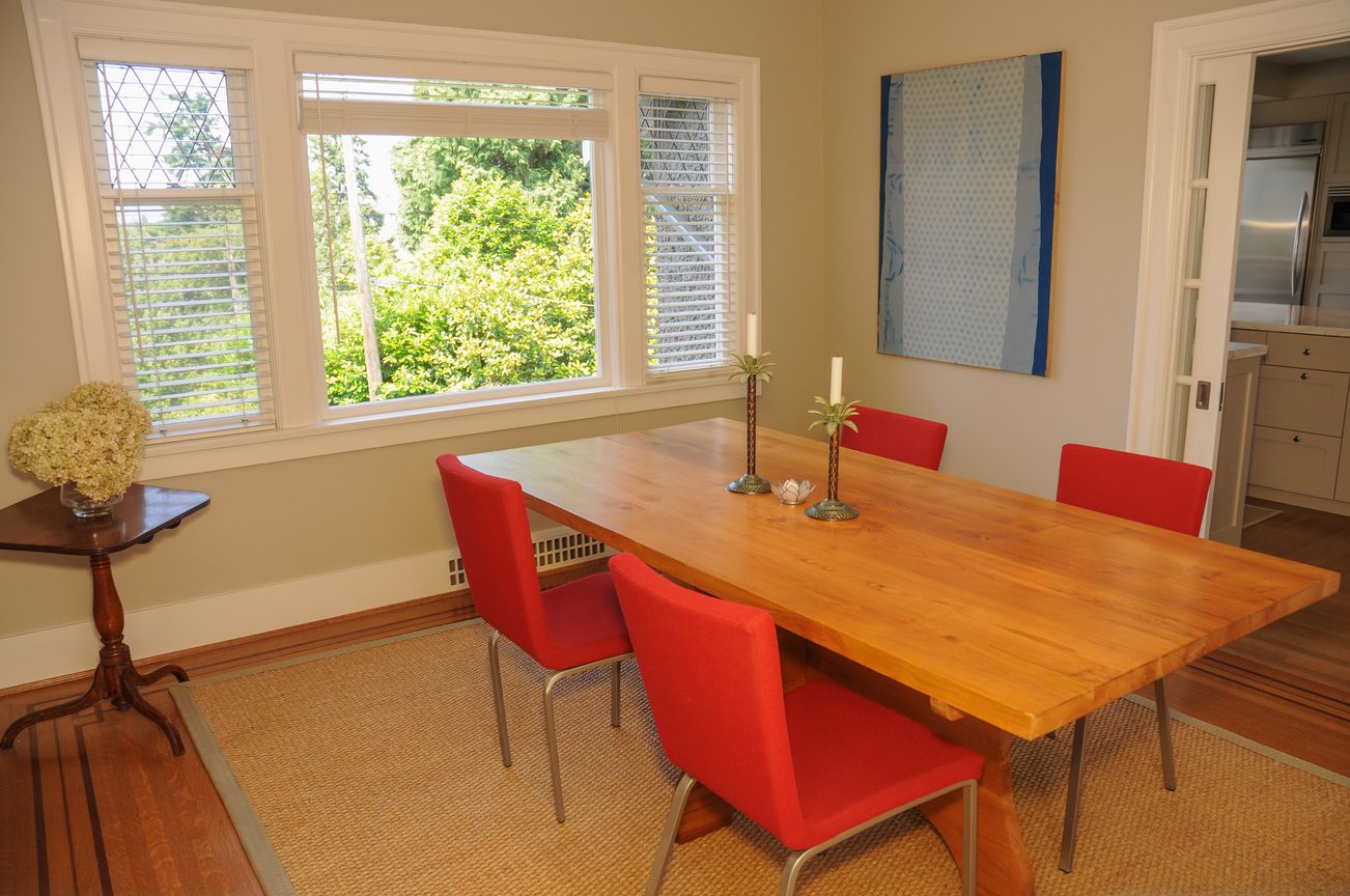 Bright dining room with wooden table, red chairs, and large windows with greenery view. - 2037 Quilchena Crescent, Vancouver West Side