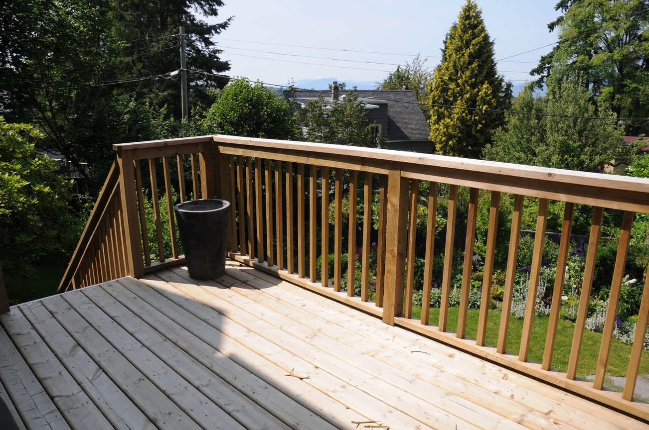 Furnished deck with wooden railing and lush greenery, overlooking a quiet neighborhood. - 2037 Quilchena Crescent, Vancouver West Side