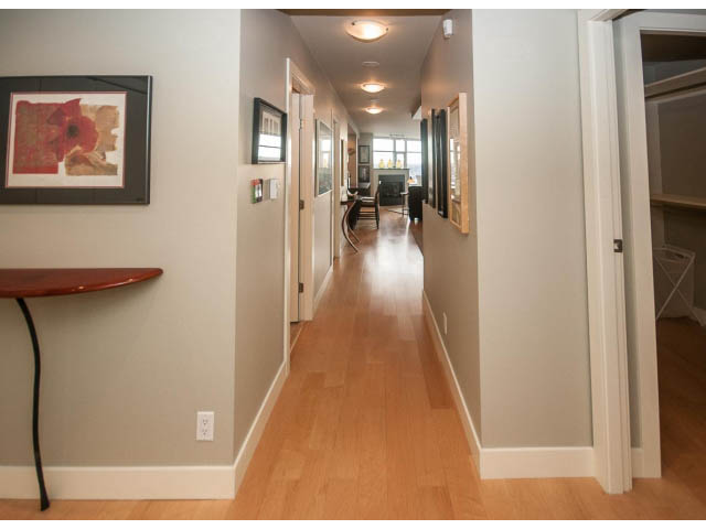 Furnished hallway with hardwood floors and artwork on the walls. - 2901 - 1199 Marinaside, Vancouver Downtown