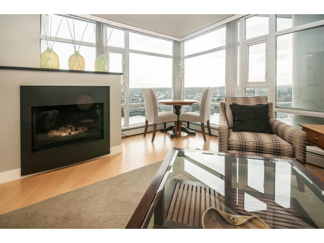 Furnished living room with hardwood floors, city view, and modern fireplace. - 2901 - 1199 Marinaside, Vancouver Downtown