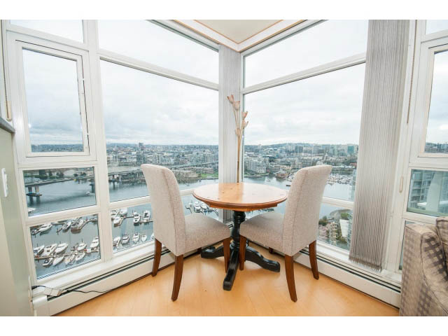 Bright dining area with city view and wooden table, hardwood floors. - 2901 - 1199 Marinaside, Vancouver Downtown