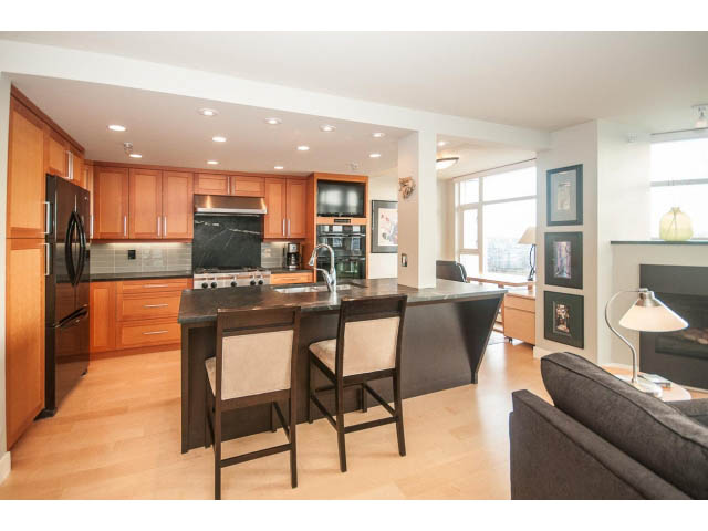 Furnished kitchen with granite countertops, hardwood floors, and a city view. - 2901 - 1199 Marinaside, Vancouver Downtown