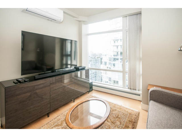 Bright living room with large TV, hardwood floors, and city view. - 2901 - 1199 Marinaside, Vancouver Downtown