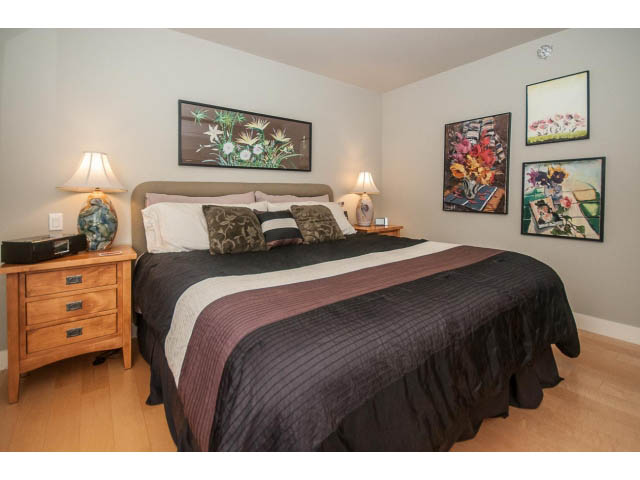 Furnished bedroom with hardwood floors, cozy bedding, and artwork on the walls. - 2901 - 1199 Marinaside, Vancouver Downtown