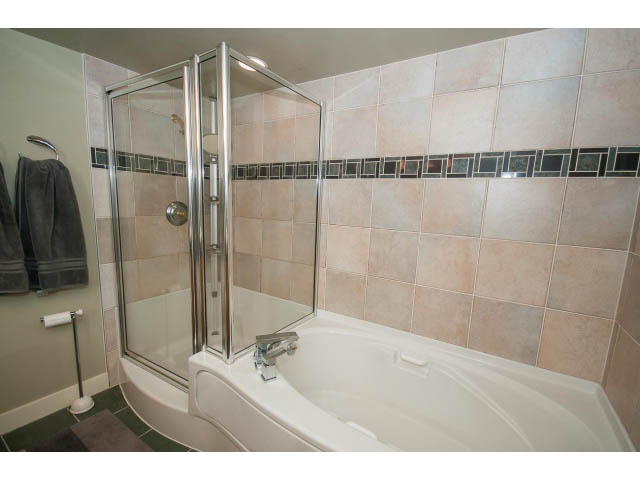 Bright bathroom with tiled walls, modern shower, and bathtub. - 2901 - 1199 Marinaside, Vancouver Downtown