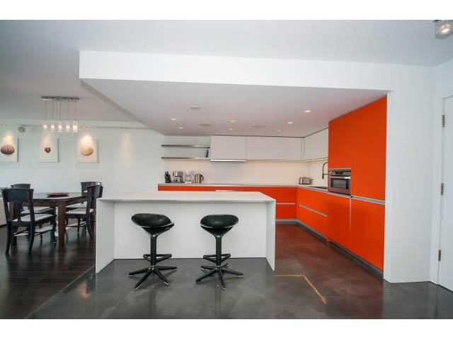 Bright kitchen with orange and white cabinetry, modern bar stools, and dark flooring. - 806 - 518 Moberly Rd, Vancouver West Side