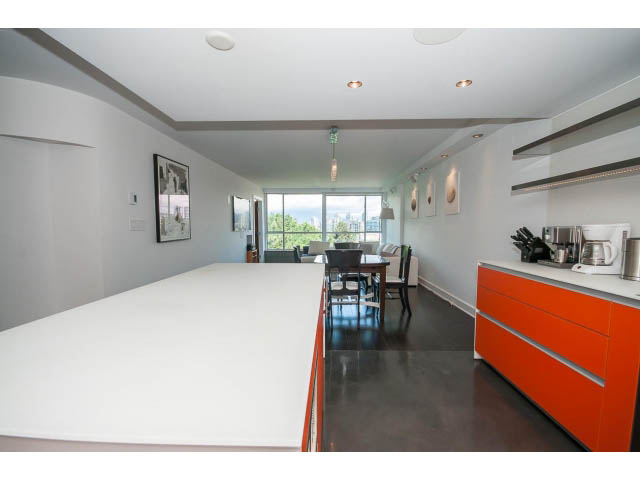 Bright kitchen with modern orange cabinets, sleek countertops, and a city view. - 806 - 518 Moberly Rd, Vancouver West Side