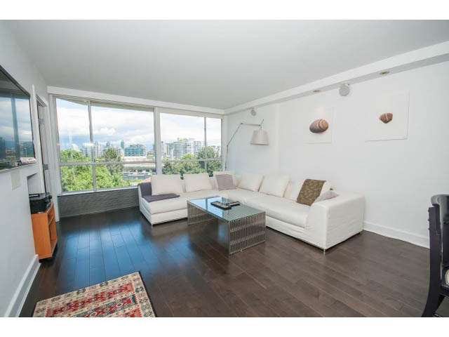 Spacious living room with hardwood floors, city view, and modern furniture. - 806 - 518 Moberly Rd, Vancouver West Side