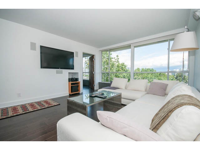 Spacious living room with large windows, hardwood floors, and a city view. - 806 - 518 Moberly Rd, Vancouver West Side