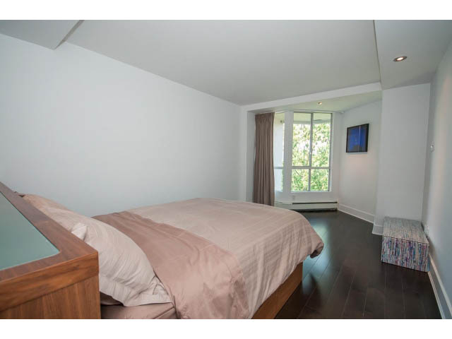 Spacious bedroom with wooden floors, large window, and modern furnishings. - 806 - 518 Moberly Rd, Vancouver West Side