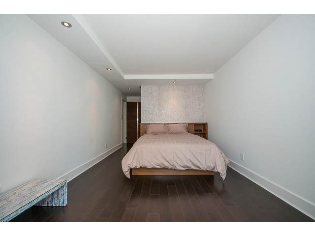Furnished bedroom with hardwood floors and a modern bed frame. - 806 - 518 Moberly Rd, Vancouver West Side