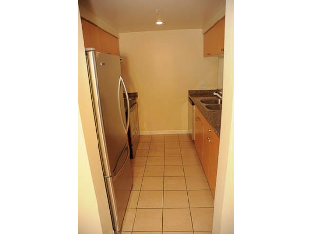 Bright kitchen with stainless steel appliances and light-colored countertops. - 606-1228 Marinaside Crescent, Vancouver Downtown