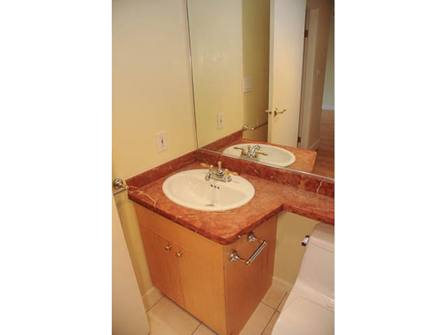 Furnished bathroom with marble countertops and wooden cabinets. - 606-1228 Marinaside Crescent, Vancouver Downtown