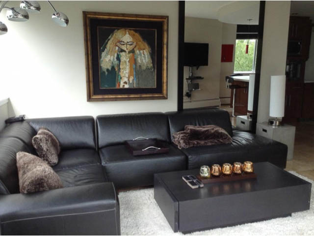 Bright living room with black leather sectional, modern coffee table, and large artwork on the wall. - 501 - 1251 Cardero Street, Vancouver Downtown