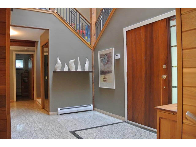 Furnished living room with modern decor, wooden accents, and a view of the staircase. - 2450 Riverside Drive, North Vancouver