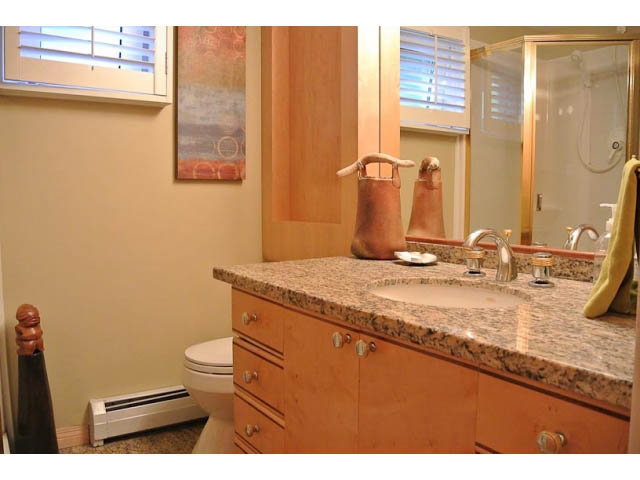Bathroom with granite countertops and wooden cabinets. - 2450 Riverside Drive, North Vancouver