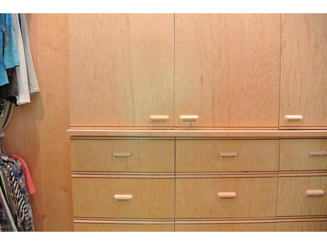 Furnished bedroom with light wood cabinetry and closet space. - 2450 Riverside Drive, North Vancouver