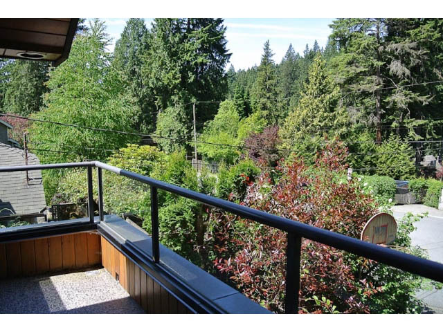 Furnished balcony with lush greenery and forest view. - 2450 Riverside Drive, North Vancouver