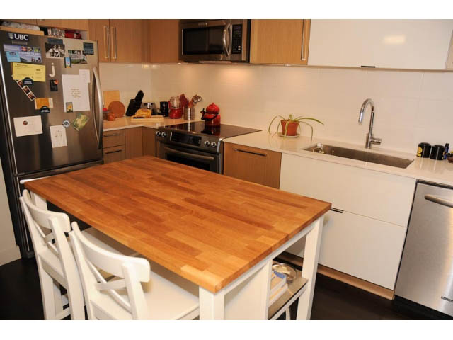Bright kitchen with wooden countertops and stainless steel appliances, perfect for a cozy living space. - 306-215 East 33rd Ave, Vancouver East Side