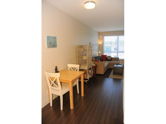 Bright dining area with wooden table and chairs, hardwood floors, and a city view. - 306-215 East 33rd Ave, Vancouver East Side