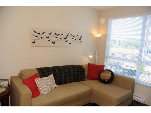 Bright living room with plaid throw pillows and city view. - 306-215 East 33rd Ave, Vancouver East Side