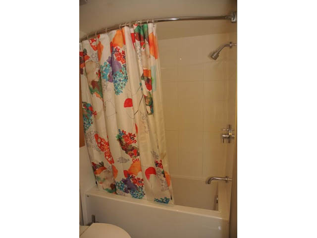Furnished bathroom with colorful floral shower curtain and modern fixtures. - 306-215 East 33rd Ave, Vancouver East Side