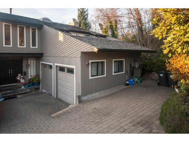 Furnished suite with brick driveway, large windows, and outdoor plants. - Suite- 3897 St. Pauls Ave, North Vancouver