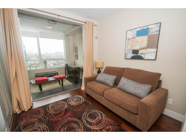 Furnished living room with hardwood floors, city view, and modern art. - 508 - 1675 West 8th Ave, Vancouver West Side