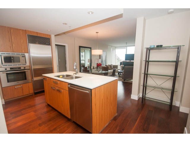 Bright kitchen with stainless steel appliances, hardwood floors, and a city view. - 508 - 1675 West 8th Ave, Vancouver West Side