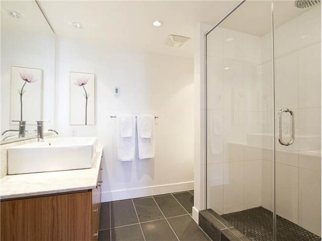 Bright bathroom with white tiles, modern sink, and glass shower enclosure. - 508 - 1675 West 8th Ave, Vancouver West Side