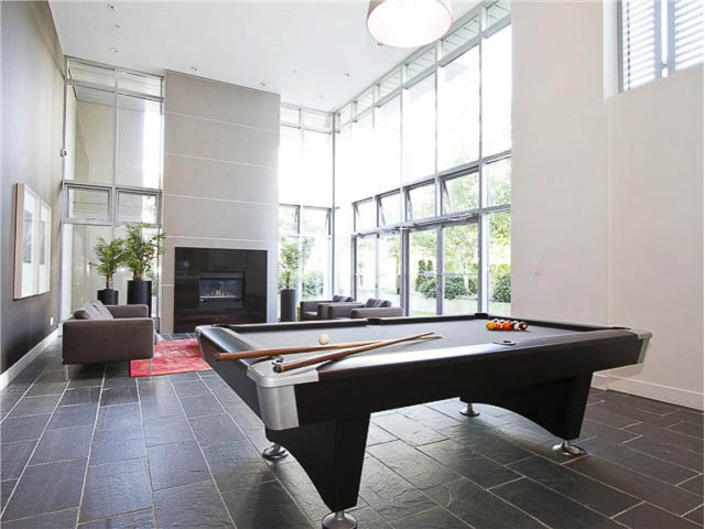 Bright living room with large windows, modern furniture, and a pool table. - 508 - 1675 West 8th Ave, Vancouver West Side