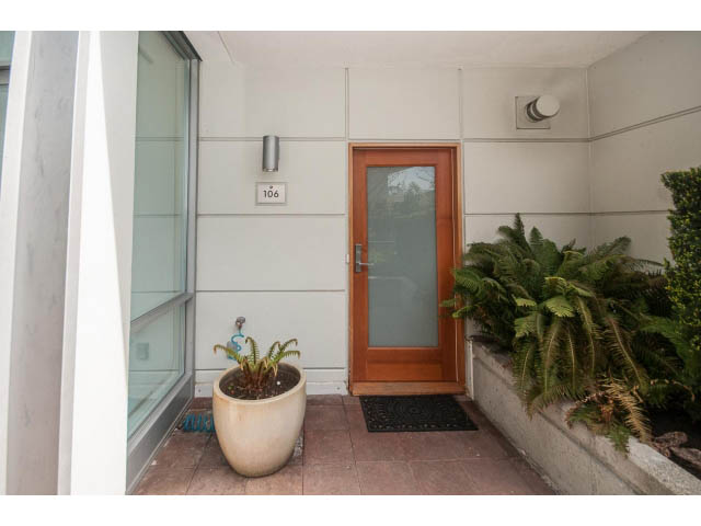 Furnished entryway with wooden door, potted plants, and modern decor. - 106 - 633 Kinghorne Mews, Vancouver Downtown