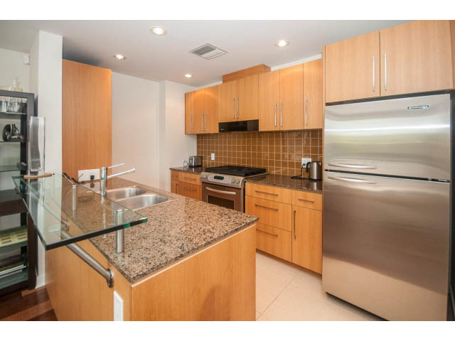 Bright kitchen with granite countertops, stainless steel appliances, and wooden cabinets. - 106 - 633 Kinghorne Mews, Vancouver Downtown
