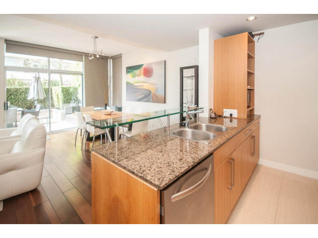Bright kitchen with granite countertops, hardwood floors, and a city view. - 106 - 633 Kinghorne Mews, Vancouver Downtown