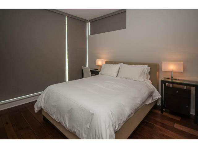 Spacious bedroom with hardwood floors and modern lighting. - 106 - 633 Kinghorne Mews, Vancouver Downtown