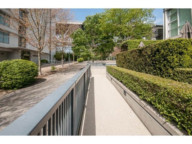Spacious outdoor patio with lush greenery and modern architecture. - 106 - 633 Kinghorne Mews, Vancouver Downtown