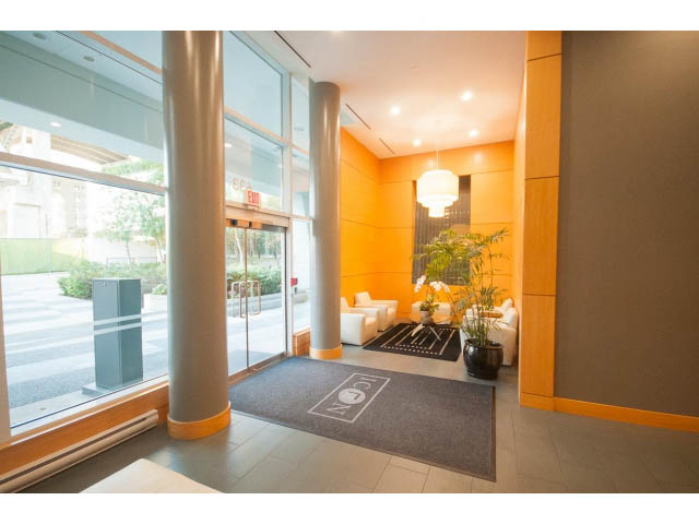 Furnished living room with modern decor, large windows, and city view. - 106 - 633 Kinghorne Mews, Vancouver Downtown