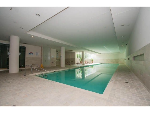 Spacious open-concept living area with modern decor and large windows. - 106 - 633 Kinghorne Mews, Vancouver Downtown
