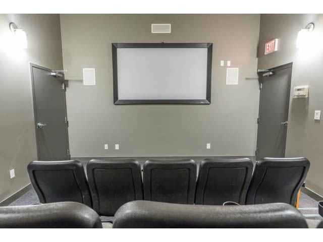 Living room with modern seating and a large projection screen. - 106 - 633 Kinghorne Mews, Vancouver Downtown